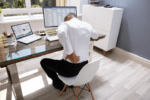 man leaning over desk with back pain